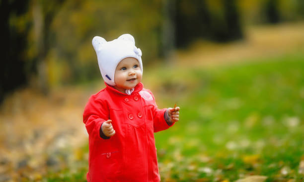 l’enfant dans le feuillage d’automne fait ses premiers pas - baby first steps autumn child photos et images de collection