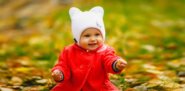 l’enfant dans le feuillage d’automne fait ses premiers pas - baby first steps autumn child photos et images de collection