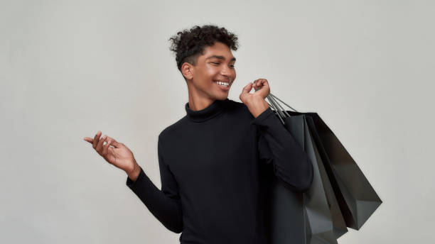istock Cheerful young african american guy after shopping 1305605562