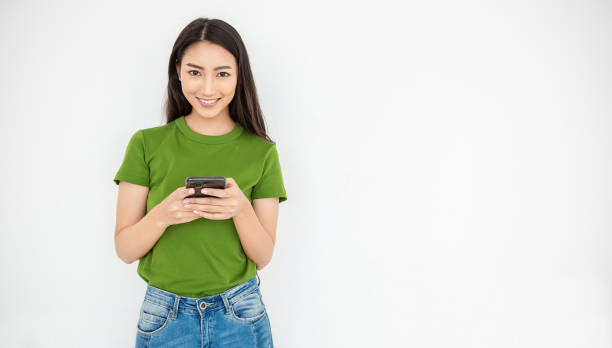 ritratto di bella ragazza d'affari asiatica alla moda giapponese festeggia con lo smartphone con spazio di copia su sfondo bianco. successo e felice donna educazione internet tecnologia startup business. - japanese ethnicity women asian and indian ethnicities female foto e immagini stock