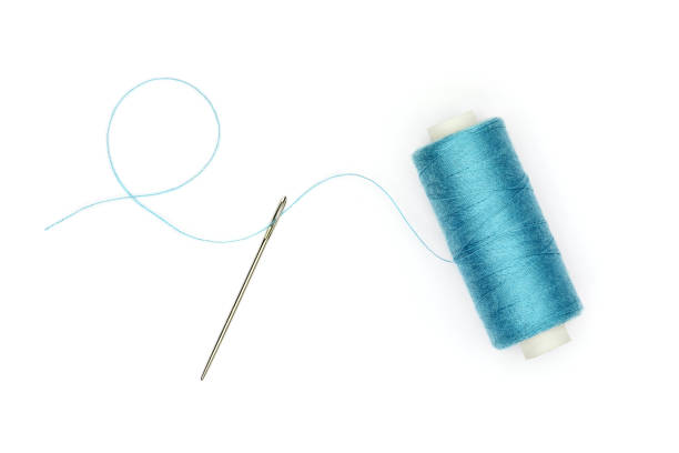 istock Wire reel with thread passing through the isolated needle on a white background. 1305610885