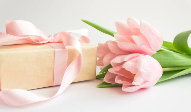 istock gift box and pink tulips 1305611917