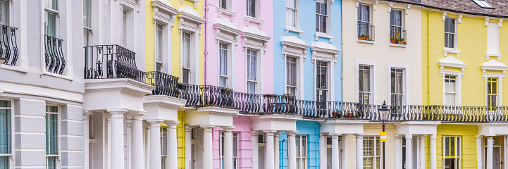 Terrace of colourfully painted period family homes on a quiet residential street in London, UK.