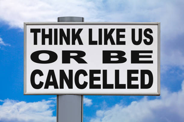 Think like us or be cancelled - Billboard Close-up on a white billboard against a blue sky with the message "Think like us or be cancelled" written in black in the middle. dictator photos stock pictures, royalty-free photos & images