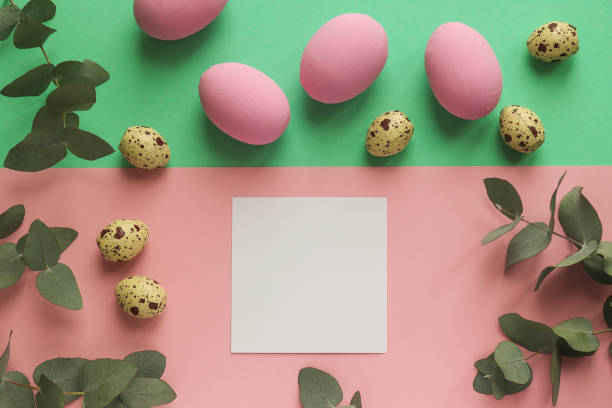 istock Easter mock up. Colorful easter eggs and quail eggs on geometric pink and green background with eucalyptus decorative leaves end empty paper blank. Creative minimal style, pop art design 1305621036