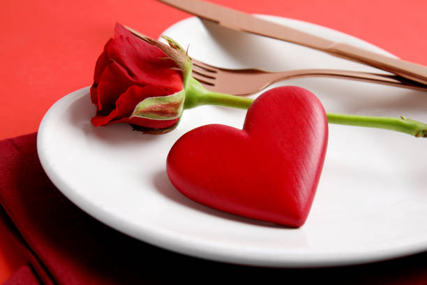 istock Elegant table setting for romantic dinner on red background, closeup. Valentine's day celebration 1305621891
