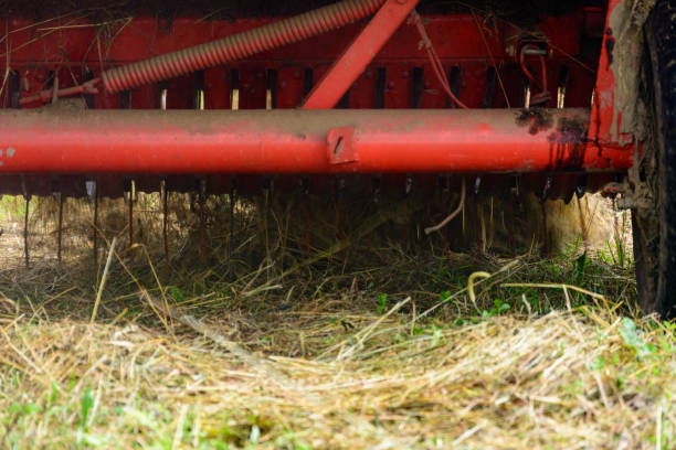 the process of pressing hay into bales, the work of the press machine, the mechanism and details of the press. - agricultural machinery retro revival summer farm imagens e fotografias de stock