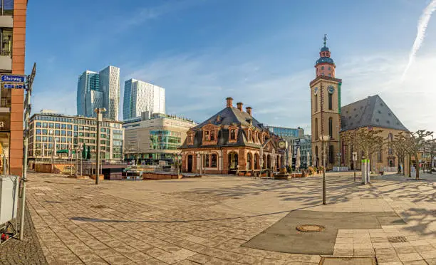 View over the square at the Hauptwache in Frankfurt with St. Catherine's Church and skyscrapers of the skyline in winter morning light