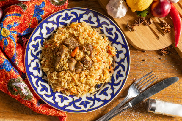 Traditional Uzbek pilaf with lamb and vegetables Pilaf with lamb. Traditional oriental hot dish of boiled rice, lamb, vegetables and spices in a plate with national Uzbek ornaments. pilau rice stock pictures, royalty-free photos & images