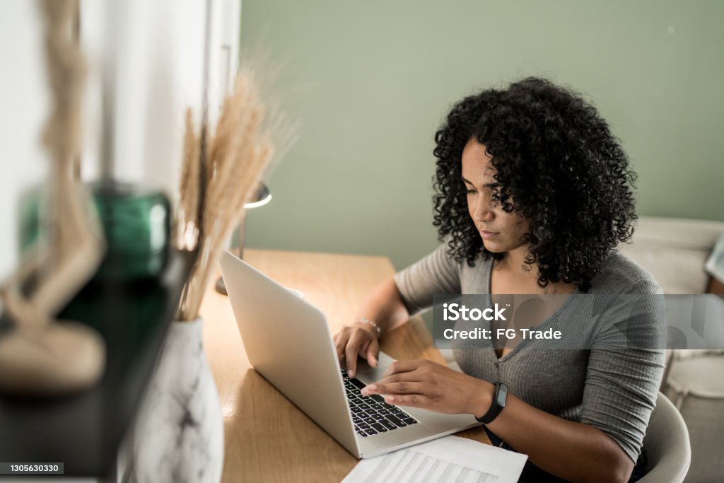 Young woman using laptop working at home One Woman Only Stock Photo
