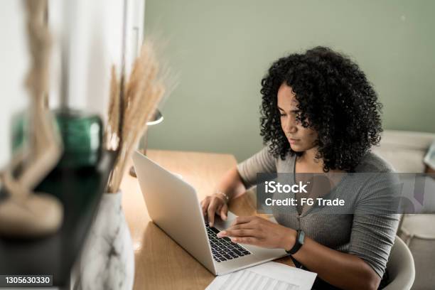 Young Woman Using Laptop Working At Home Stock Photo - Download Image Now - One Woman Only, Domestic Life, Research