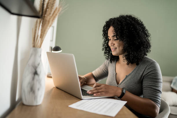istock Young woman using laptop working at home 1305630385