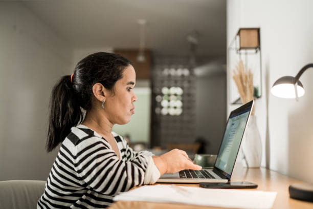 Dwarfism woman using laptop working from home Dwarfism mid adult woman using laptop working from home short stature stock pictures, royalty-free photos & images