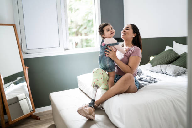 disability mother playing with baby girl at home - baby carrier fotos imagens e fotografias de stock