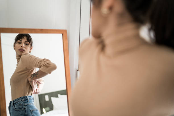 joven se viste frente a un espejo en casa - probador establecimiento comercial fotografías e imágenes de stock