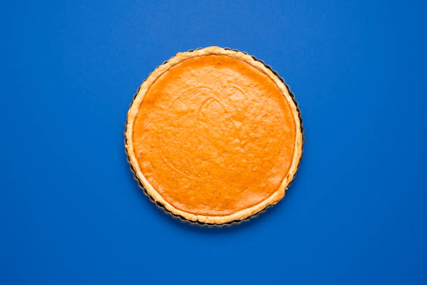 istock Pumpkin pie top view minimalist on a blue background. 1305631487
