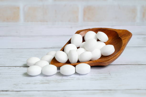 istock White naphthalene balls on white wooden background 1305632423