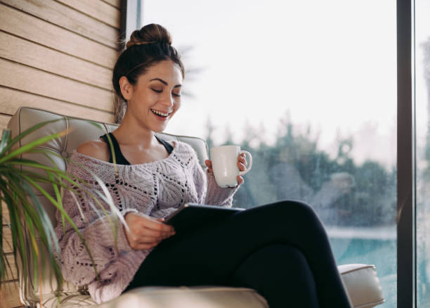 istock Young Woman Using Digital Tablet At Home Nearby Window 1305632818
