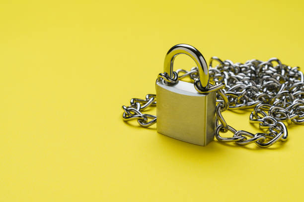 Padlock and chain on color background
