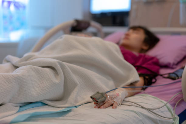 Asian female patient warded and laying on the bed connected to multiple medical devices Asian female patient warded and laying on the bed connected to multiple medical devices miscarriage stock pictures, royalty-free photos & images