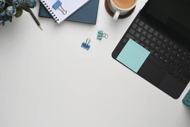 istock Workspace top view computer keyboard and coffee with notebook paper on white desk. 1305634912