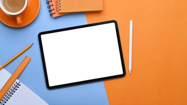 istock Empty screen of digital tablet on two tone background with office supplies. 1305634934