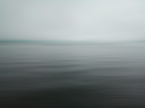 Minimalism scene of misty morning background in the sea. Fog over lake wave water. Calm beach view. Tranquil empty landscape with soft blue gray gloomy sky. Nature abstract art backgrounds. Copy space