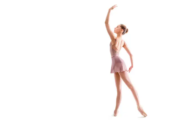 young ballerina in pointe shoes poses in graceful pose isolated on white background