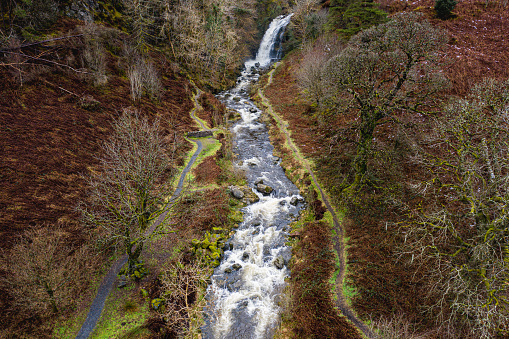 The view from a drone of a small Scottish river and waterfall after heavy rain the location is in Dumfries and Galloway south west Scotland
