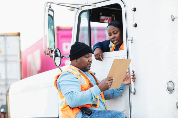 женщина водитель грузовика, док-работник глядя на буфер обмена - truck driver serious cargo container reading стоковые фото и изображения