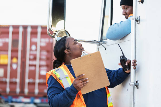 водитель грузовика, женщина док-работник с буфер обмена - truck driver serious cargo container reading стоковые фото и изображения
