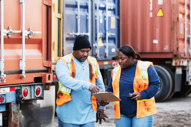 istock Two workers at freight company talking,, with clipboard 1305640689