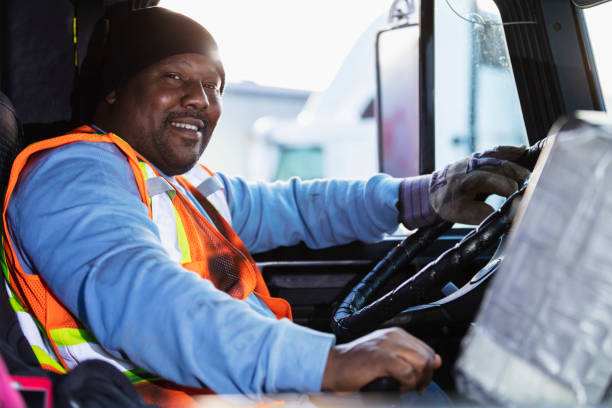 African-American man driving a semi-truck A mature African-American man in his 40s driving a semi-truck. He is sitting in the driver's seat, looking at the camera, smiling. semi truck photos stock pictures, royalty-free photos & images