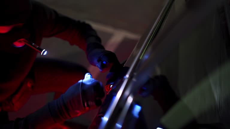 Skilled car thief picking the lock of car doors