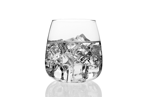 glass of water with ice cubes, reflected and isolated on white background