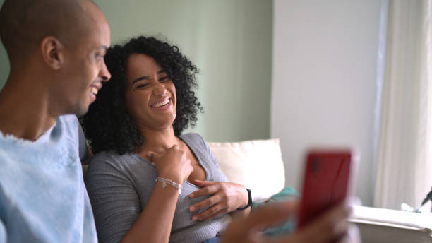 istock Couple watching something on smartphone or doing video call at home 1305644291