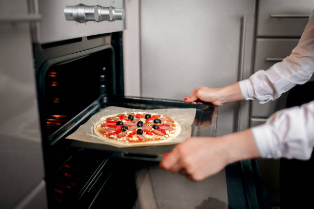 istock Raw pizza with ingredients on baking tray 1305644652