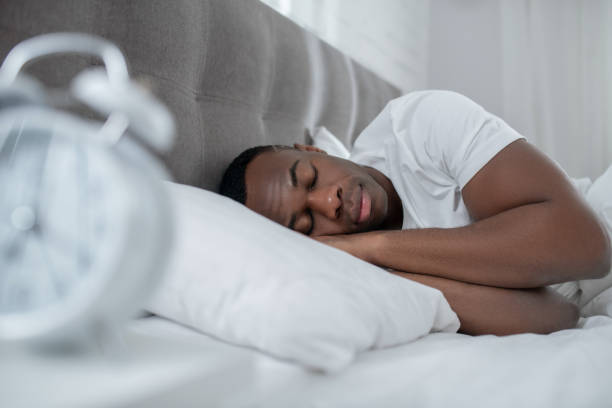 istock A young man in white tshirt lying in bed and looking sleepy 1305646193