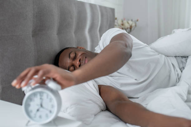 istock A young man in white tshirt lying in bed and looking sleepy 1305646196