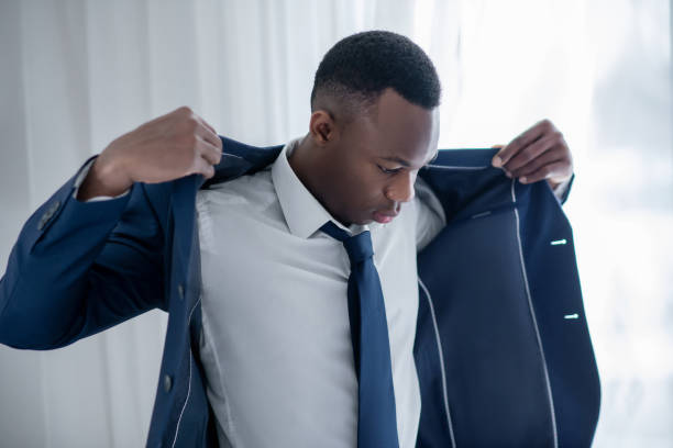 A young african american man wearing a jacket and looking elegant