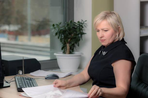 istock A female director working in an office is sitting at a table, analyzing business statistics, checking documents. 1305647289