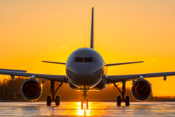 istock Grey with red airplane taxiing at sunrise 1305649431