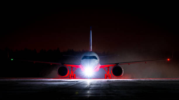 istock White with red airplane taxiing at night 1305649504