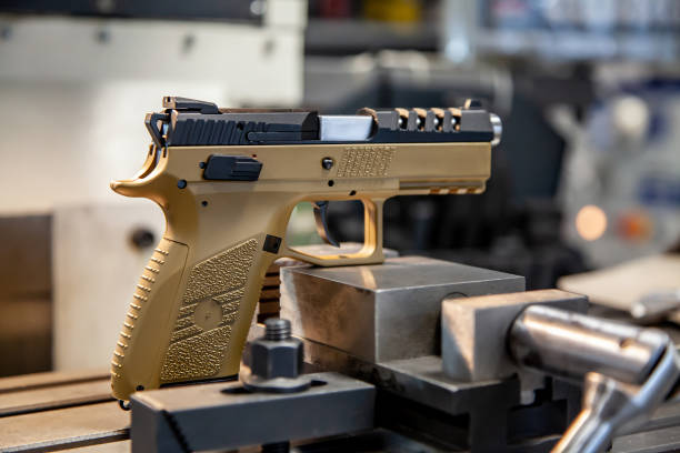 istock A modern pistol with a beige grip on a work table in a workshop. Service maintenance of weapons. Pistol repair. 1305649525