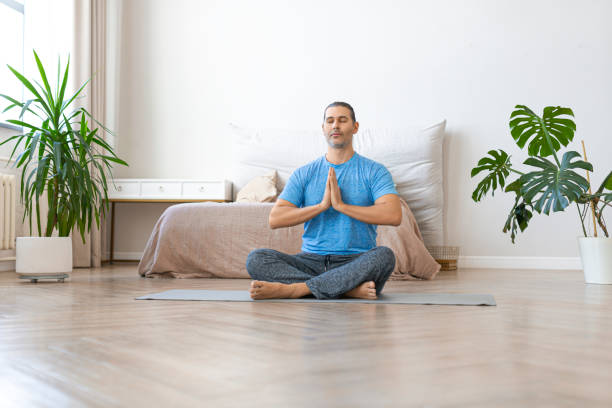 istock Workout at home. Middle aged man meditating while doing yoga 1305650478