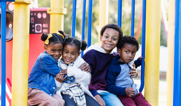istock Four young siblings hugging on playground 1305651539