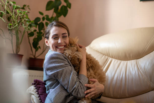 istock Young brunette holding and hugging cute toy poodle. 1305651960