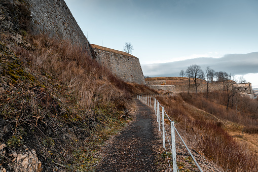 Path for tourists, secured by a railing, outside, along the walls of the Klodzko Fortress.