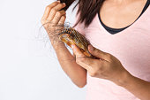 istock Woman hand hoding hairs fall in comb, hair fall everyday serious problem 1305655753