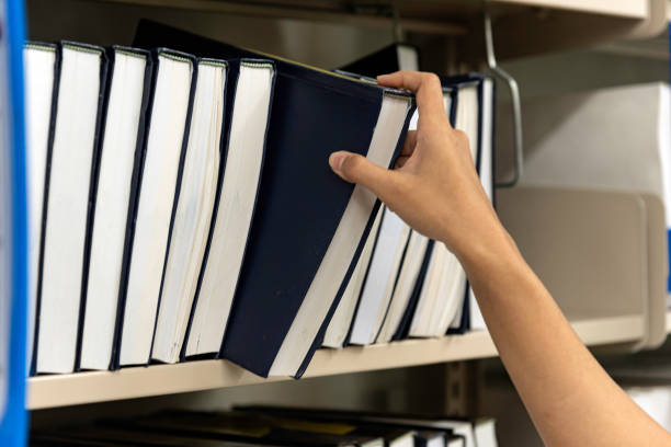 istock In the library,Asian student search book between the shelves. 1305659147